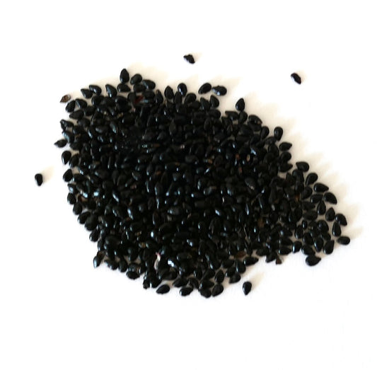 About three hundred black seeds of small Pilosocereus pentaedrophorus on a white surface